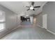 Spacious living room with light gray flooring, a ceiling fan, and views of the modern kitchen at 13169 Odyssey Lake Way, Orlando, FL 32826