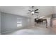 Spacious living room with light gray flooring, a ceiling fan, and views of the modern kitchen at 13169 Odyssey Lake Way, Orlando, FL 32826