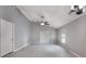 A spacious primary bedroom with a ceiling fan, light gray walls, and sliding glass door at 13169 Odyssey Lake Way, Orlando, FL 32826