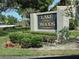 Lake of the Woods Townhomes sign is surrounded by lush, green landscaping at 136 Teriwood Ct, Fern Park, FL 32730