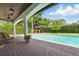 Backyard area featuring brick pavers, covered patio with outdoor furniture, a pool, and beautiful landscaping at 1361 Palmer Ave., Winter Park, FL 32789