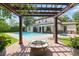 View from under the pergola toward the pool, hot tub, outdoor kitchen, and the home at 1361 Palmer Ave., Winter Park, FL 32789