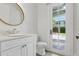 Elegant bathroom featuring a white vanity, gold mirror, and a door leading to the outdoor pool area at 1361 Palmer Ave., Winter Park, FL 32789