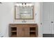 Bathroom vanity with storage, white countertops, and framed mirror over sink and view of walk-in shower at 1361 Palmer Ave., Winter Park, FL 32789