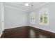 Bedroom with dark hardwood floors, white trim, ceiling fan and two large windows with blinds at 1361 Palmer Ave., Winter Park, FL 32789