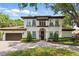 Stately two-story home featuring a terracotta roof, arched windows with flower boxes and lush landscaping at 1361 Palmer Ave., Winter Park, FL 32789