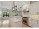 Modern kitchen with island, stainless steel appliances, white cabinets, and stylish pendant lighting at 1361 Palmer Ave., Winter Park, FL 32789