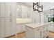 Bright kitchen with white cabinets, center island, and modern pendant lighting, perfect for cooking and gathering at 1361 Palmer Ave., Winter Park, FL 32789