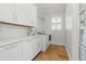 Laundry room with sink, white cabinets and counter, and front-loading washer and dryer at 1361 Palmer Ave., Winter Park, FL 32789