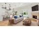 Bright living room featuring a fireplace, tan sofa with blue pillows, and direct access to the outdoor pool area at 1361 Palmer Ave., Winter Park, FL 32789