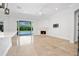 Bright living room featuring a modern fireplace, polished floors, and sliding glass doors to the backyard pool at 1361 Palmer Ave., Winter Park, FL 32789