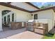 Outdoor kitchen area with stone accents, stainless steel appliances, and brick paver flooring at 1361 Palmer Ave., Winter Park, FL 32789