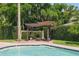 Backyard shows a pergola covered in vines located on the pool deck next to the pool at 1361 Palmer Ave., Winter Park, FL 32789
