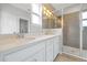Bright bathroom features a double sink vanity with quartz counters and gray tiled shower at 14208 Shocklach Dr, Winter Garden, FL 34787