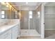 Bathroom with walk-in shower featuring gray tile and a glass enclosure; closet entrance visible at 14208 Shocklach Dr, Winter Garden, FL 34787
