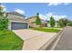 Long driveway leading to an attached two-car garage in a suburban neighborhood at 14208 Shocklach Dr, Winter Garden, FL 34787