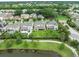 A beautiful aerial view captures home with a green lawn, trees, a walking path by the lake and neighborhood at 14516 Sunbridge Cir, Winter Garden, FL 34787