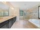 Spacious bathroom with a soaking tub, dual sinks, a glass shower and ceramic tile floors at 14516 Sunbridge Cir, Winter Garden, FL 34787