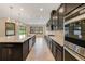 Modern kitchen with dark cabinetry, an oversized island, stainless steel appliances, and recessed lighting at 14516 Sunbridge Cir, Winter Garden, FL 34787