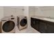 Well-equipped laundry room features modern washer and dryer, countertop, and storage cabinets with shelving at 14516 Sunbridge Cir, Winter Garden, FL 34787