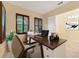 Bright home office featuring a wooden desk, plantation shutters, and neutral décor at 14516 Sunbridge Cir, Winter Garden, FL 34787