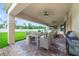 Inviting covered patio with brick flooring, ceiling fans, a dining table, and outdoor grill at 14516 Sunbridge Cir, Winter Garden, FL 34787