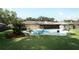 Expansive backyard with a sparkling pool, lush lawn, mature trees, and comfortable seating arrangements at 1529 Ensenada Dr, Orlando, FL 32825