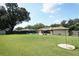 Large backyard features an in-ground pool, lawn, patio, and mature trees at 1529 Ensenada Dr, Orlando, FL 32825