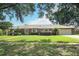 Charming brick single-story home with a well-manicured lawn, mature trees, and attached two car garage at 1529 Ensenada Dr, Orlando, FL 32825