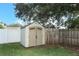Backyard shed with double doors and windows against a wood fence and lawn at 1529 Ensenada Dr, Orlando, FL 32825