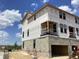 A new construction home showcases modern architecture and expansive windows under blue sky at 15447 Hamlin Park Drive, Winter Garden, FL 34787