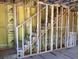 Unfinished staircase with exposed wooden framing and yellow insulation behind it at 15447 Hamlin Park Drive, Winter Garden, FL 34787