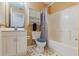 Bright bathroom boasts tiled floors, shower-tub, and updated vanity with storage at 160 Chestnut Ave, Orange City, FL 32763