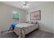 Cozy bedroom featuring a ceiling fan, carpeted floors, and natural light from the window at 160 Chestnut Ave, Orange City, FL 32763