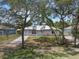 Frontal view of a cozy, single-story home with a metal roof, carport, and mature trees at 160 Chestnut Ave, Orange City, FL 32763