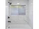Shower and tub with white marble-style tile and black hardware and window at 1633 Pinehurst Dr, Casselberry, FL 32707