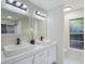Elegant bathroom boasts double vanity, black fixtures, and a colorful accent window at 1633 Pinehurst Dr, Casselberry, FL 32707