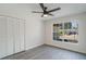 Bright bedroom with a modern ceiling fan, large window and gray-wood-style flooring at 1633 Pinehurst Dr, Casselberry, FL 32707