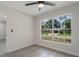 A brightly lit bedroom with gray wood flooring, fresh paint, a ceiling fan, and a large window at 1633 Pinehurst Dr, Casselberry, FL 32707