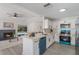 Modern kitchen with white cabinets, stainless steel appliances, and a view of the living room and pool at 1633 Pinehurst Dr, Casselberry, FL 32707