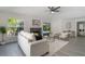 An open living room with gray wood floors, features a fireplace, and a view to the back yard and pool at 1633 Pinehurst Dr, Casselberry, FL 32707