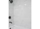 White marble-style shower and tub faucet with dark hardware and fixtures at 1633 Pinehurst Dr, Casselberry, FL 32707