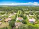 Aerial view of a neighborhood featuring tree-lined streets, well-manicured lawns, and homes with pools and ponds at 19123 Sheldon St, Orlando, FL 32833