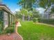 Well-manicured lawn with mature trees and landscaping, featuring a screened-in pool enclosure at 19123 Sheldon St, Orlando, FL 32833