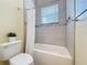 Bright bathroom features a shower-tub with decorative tile, and window at 19123 Sheldon St, Orlando, FL 32833