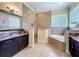 Bathroom with dual vanities, walk-in shower, soaking tub, and tile floors at 19123 Sheldon St, Orlando, FL 32833