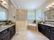 Bathroom featuring dual vanities, soaking tub, and glass block window at 19123 Sheldon St, Orlando, FL 32833