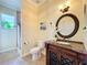 Bathroom vanity with decorative mirror, granite countertop, and tiled shower nearby at 19123 Sheldon St, Orlando, FL 32833