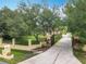 Gated driveway with mature trees and landscaping, enhancing the curb appeal of this lovely property at 19123 Sheldon St, Orlando, FL 32833