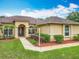 Attractive single-story home featuring a manicured lawn, beautiful landscaping, and charming architectural details at 19123 Sheldon St, Orlando, FL 32833